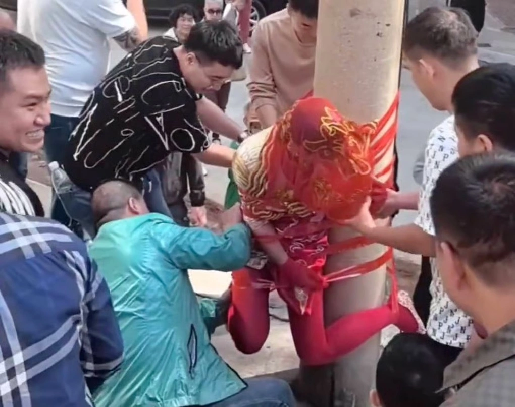 Cô dâu bị bày trò trói vào cột điện trong một video về tục náo hôn, gây nhiều quan điểm bất bình về biến tướng củ truyền thống này. Ảnh: Weibo