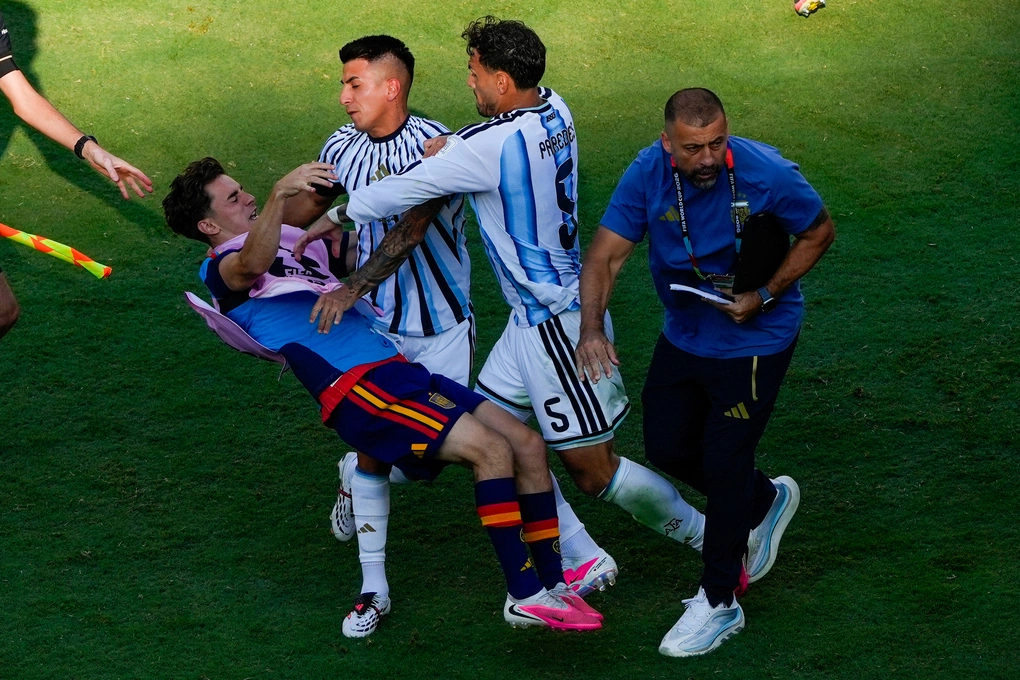 Gavi (trái) ngã xuống khi xô xát với Leandro Paredes (5) và Thiago Almada của Argentina sau trận. Ảnh: AP