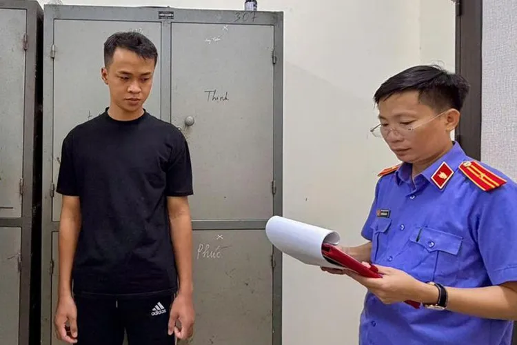 Nghi can Hoàng (góc trái) nghe đại diện Viện kiểm sát đọc lệnh khởi tố. Ảnh: Anh Quý