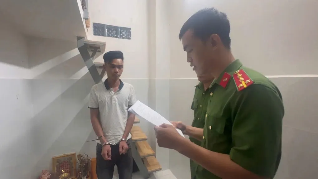 Lê Quang Trọng (trái) nghe đọc lệnh bắt. Ảnh: Công an TP HCM