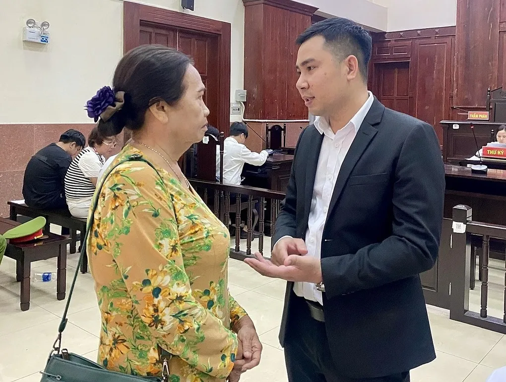 Luật sư Đàm Văn Hùng trao đổi với bà Ánh tại tòa. Ảnh: Bình Nguyên