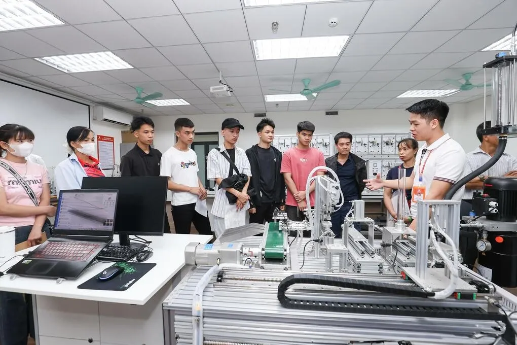 Tân sinh viên được giới thiệu hệ thống máy móc thực hành của trường. Ảnh: DNU