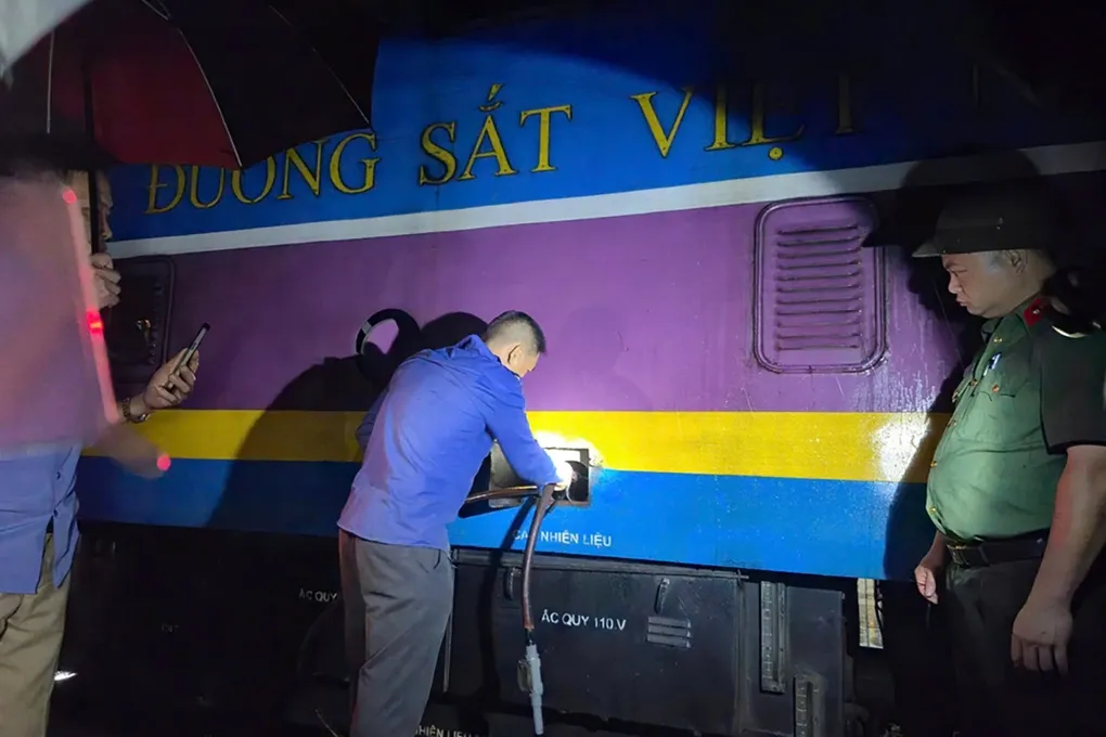 Cảnh sát bắt quả tang một nghi phạm đang hút trộm dầu tại đầu máy ở Ga Vinh hồi cuối tháng 7. Ảnh: Hòa Vang