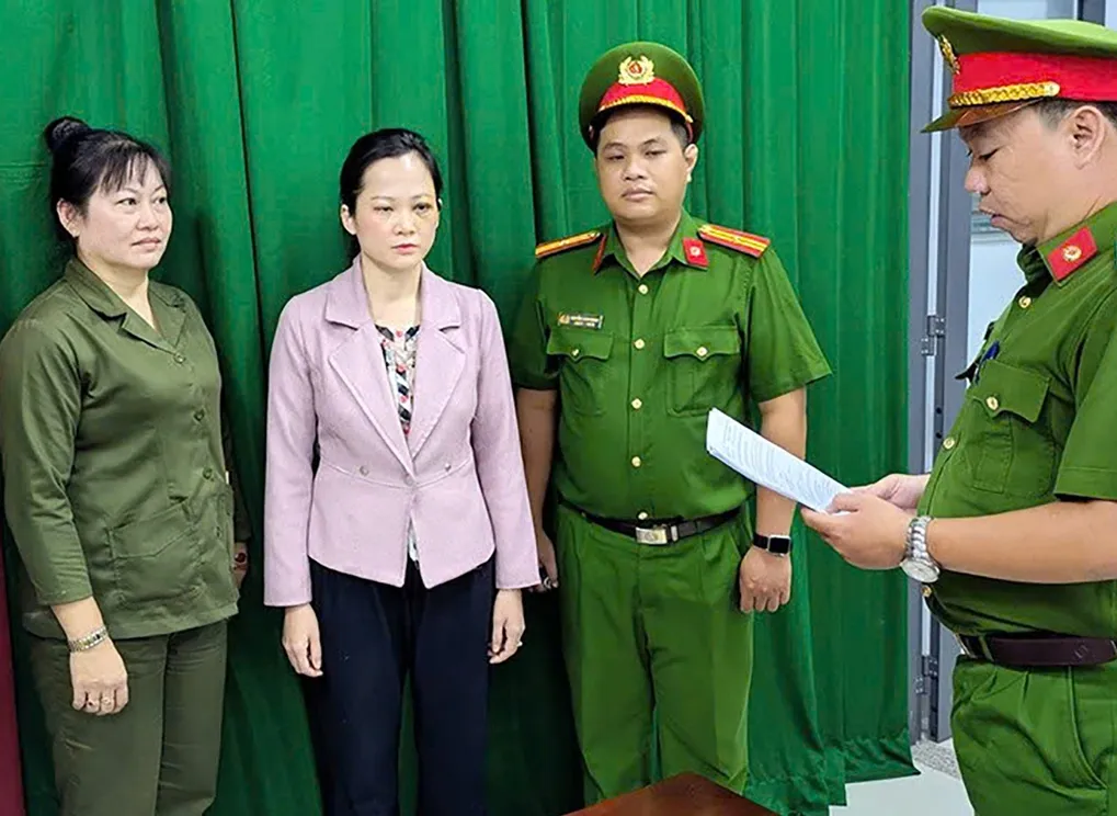 Bà Tuyết Chinh (áo hồng) lúc bị khởi tố. Ảnh: Công an cung cấp