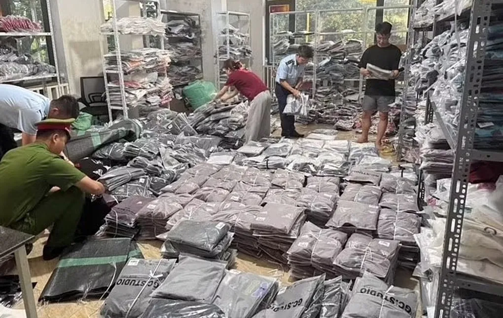 Lực lượng chức năng lập biên bản thu giữ số quần áo vi phạm. Ảnh: Công an cung cấp