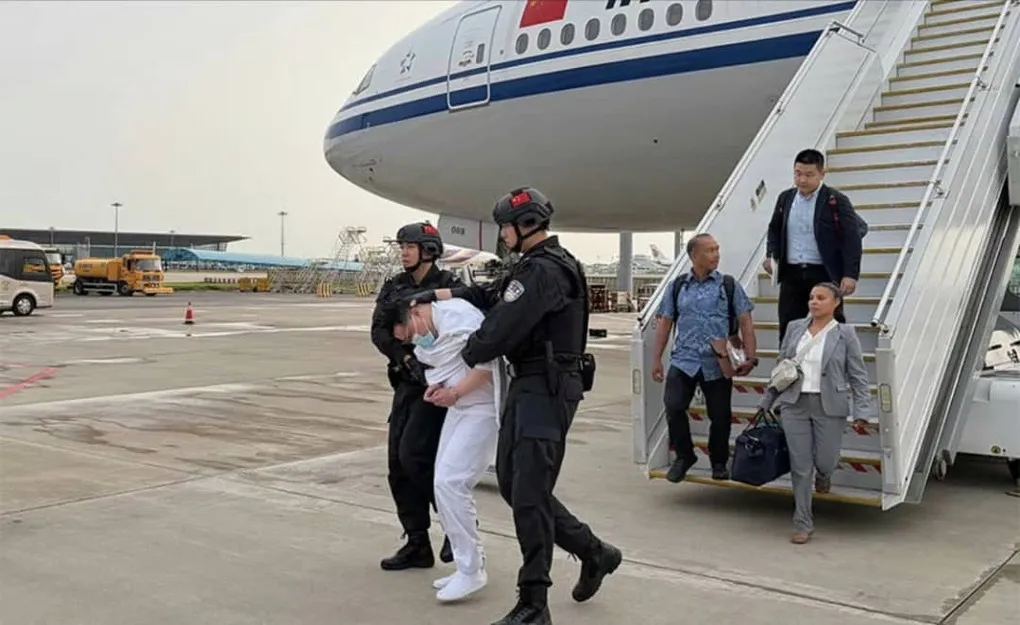Lưu Hãn Văn (đồ trắng) bị áp giải tại sân bay Bắc Kinh ngày 20/7. Ảnh: X