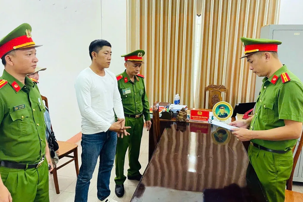Ngô Viết Hiếu nghe công an đọc lệnh bắt tạm giam. Ảnh: Thành Huynh