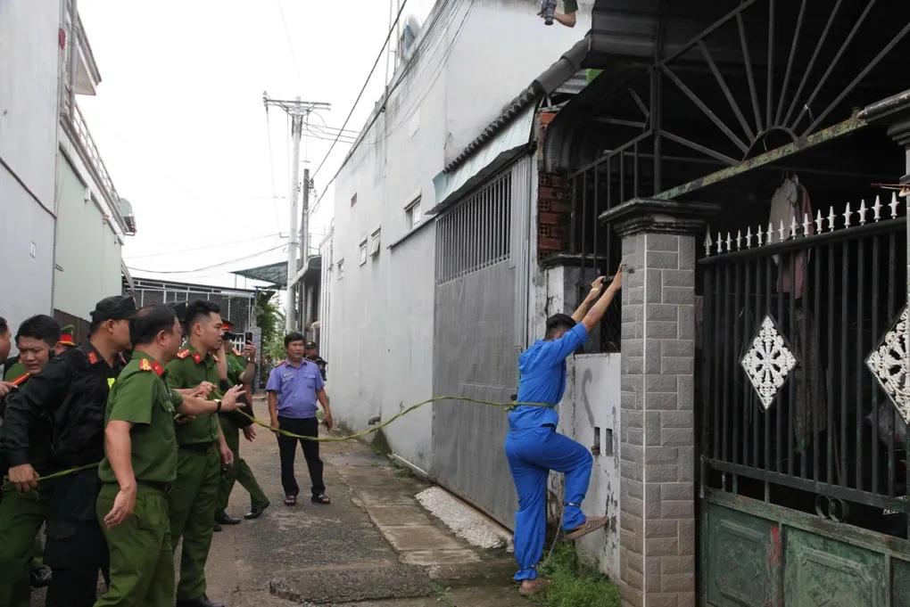 Đức Anh thực nghiệm quá trình leo rào lên mái nhà nạn nhân. Ảnh: Thái Hà