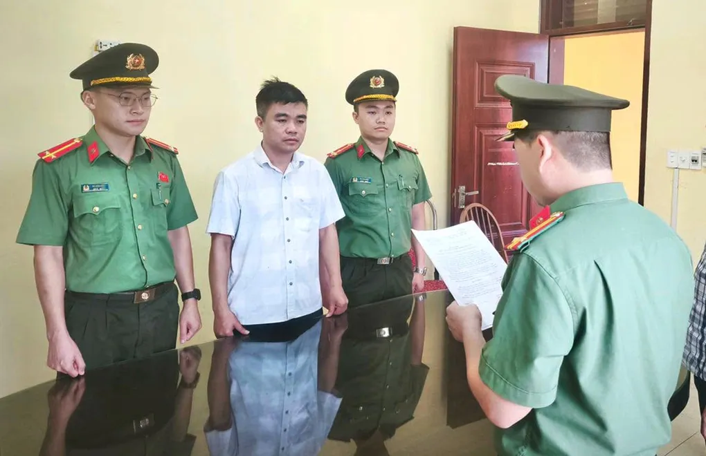 Cơ quan An ninh tống đạt quyết định khởi tố Nguyễn Văn Năm. Ảnh: Công an cung cấp