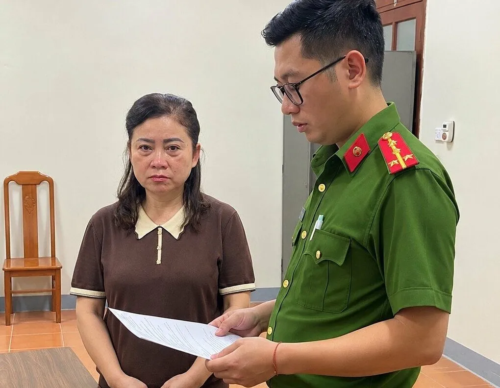 Công an tống đạt quyết định khởi tố bà Lộc Thị Hồng. Ảnh: Công an cung cấp