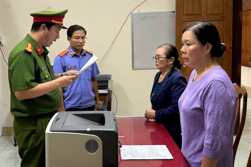 Cơ quan điều tra đọc lệnh khởi tố bà Bùi Thị Phú (đeo kính) và Nguyễn Thị  Mai. Ảnh: Văn Tài