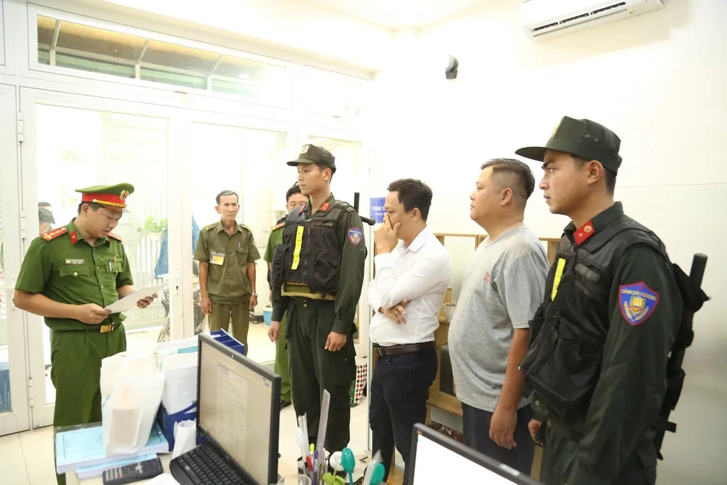 Cơ quan điều tra đọc lệnh khám xét tại một đơn vị quan trắc, phân tích môi trường ở TP HCM. Ảnh: Công an TP HCM