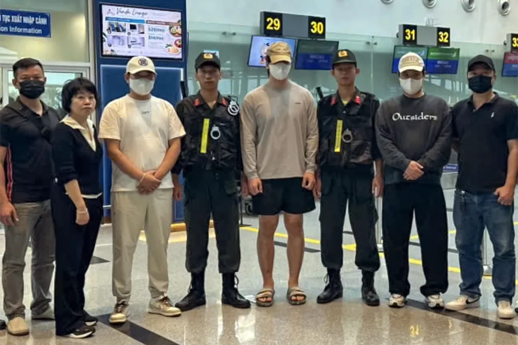 Ba người Hàn Quốc (đội mũ lưỡi trai) khi bàn giao tại sân bay quốc tế Đà Nẵng. Ảnh: Thành Huynh