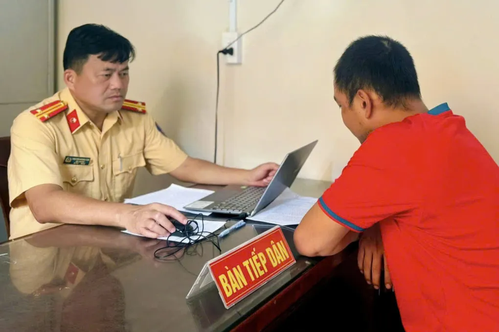 Trung tá Nguyễn Hoàng Tâm, Đội trưởng Đội CSGT Rạch Chiếc làm việc với tài xế. Ảnh: Xuân Minh