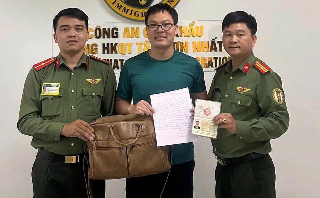 Anh Trần Văn Thạch nhận lại chiếc cặp chứa 50 triệu đồng, 3.000 USD và giấy tờ bỏ quên trong xe đẩy tại sân bay. Ảnh: Cục Quản lý xuất nhập cảnh