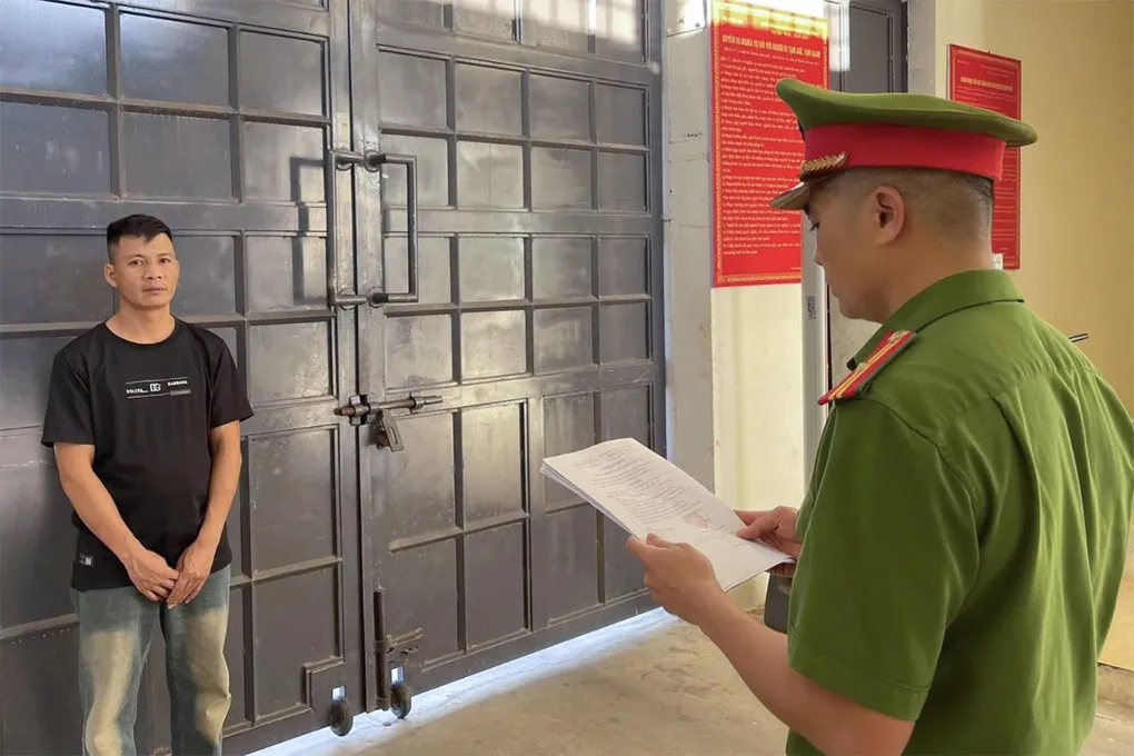 Nghi can Đạo (góc trái), nghe cảnh sát đọc lệnh khởi tố. Ảnh: Công an cung cấp